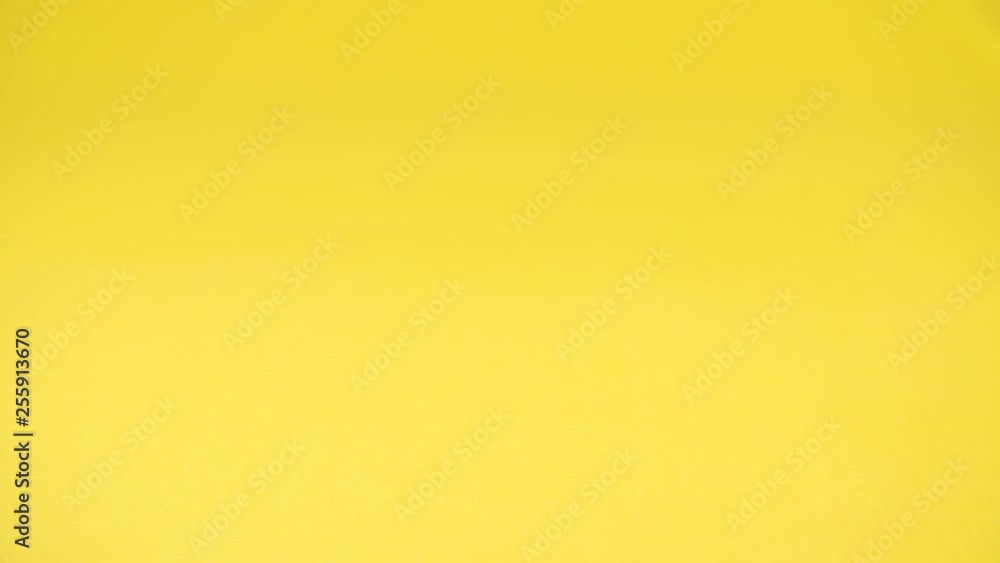Ripe banana grabbed by hand with bracelets on yellow backdrop. Ripe banana grabbed by hand with bracelets on yellow backdrop.