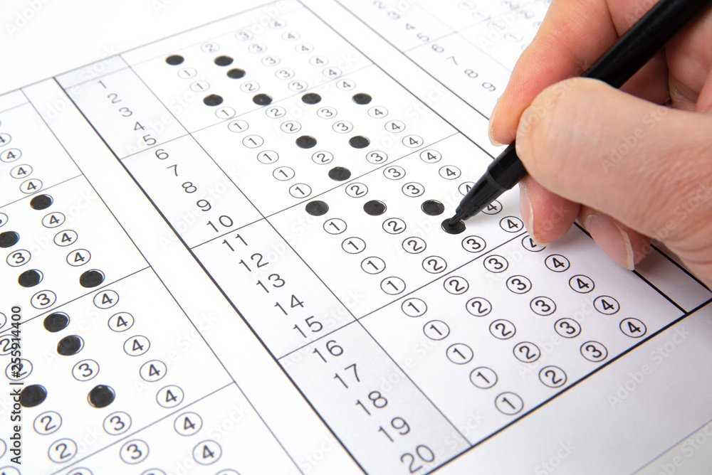 Man is filling OMR sheet handing with pen. Man is filling OMR sheet handing with pen.