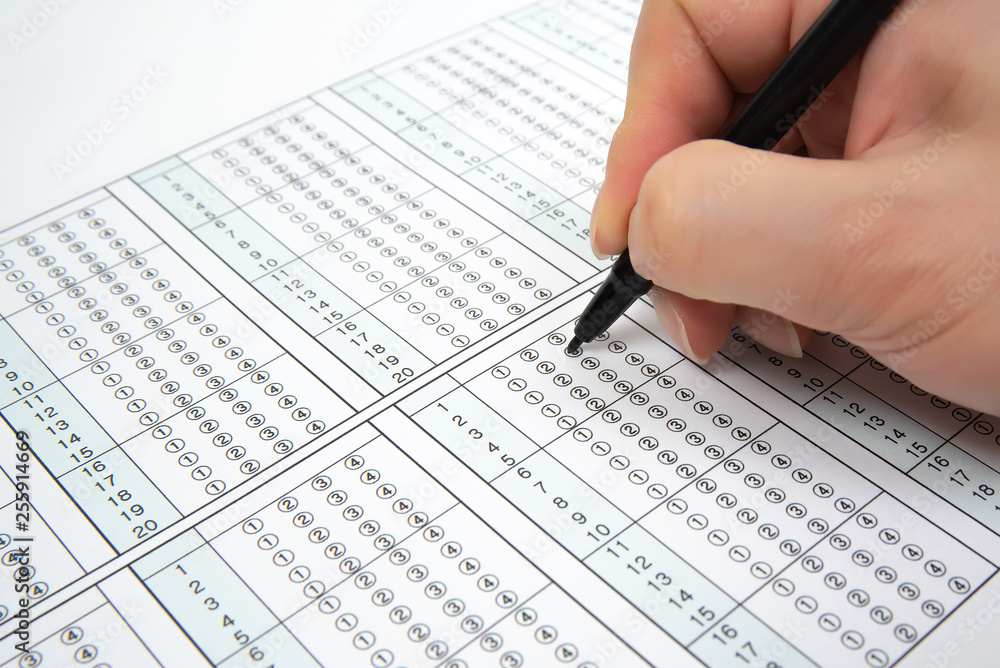 Man is filling OMR sheet handing with pen. Man is filling OMR sheet handing with pen.