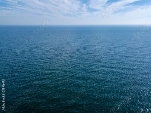 Panoramic view from drone endless blue seascape on a background of cloudy sky. Natural background. Copy space.