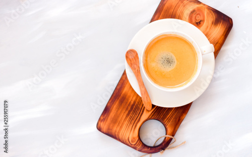 Coffee cup with a wooden spoon top view on wooden table background