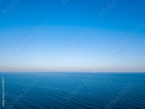 Natural scenery of blue sea or ocean with blue clear sky. Aerial view from drone. Seascape background, copy space.