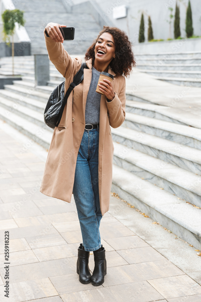 Beautiful young african woman wearing coat walking Beautiful young african woman wearing coat walking