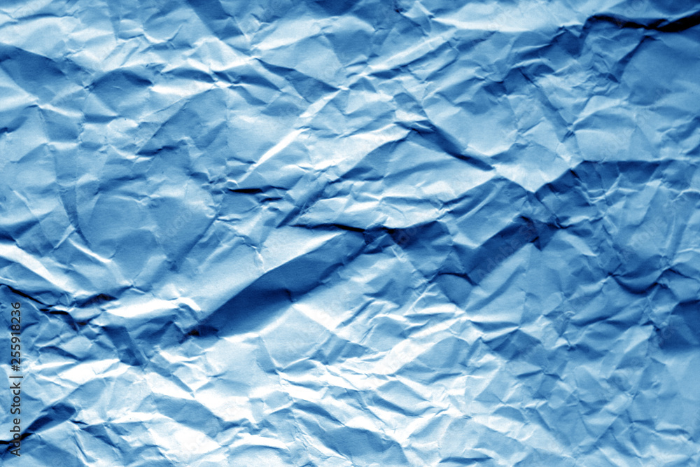 Obraz premium Crumpled sheet of paper in navy blue color.