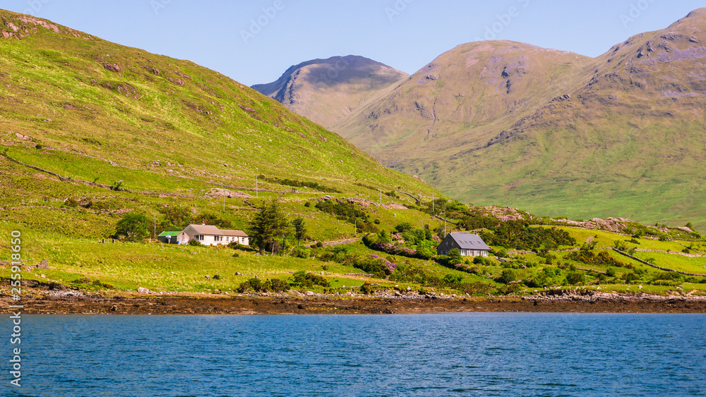 Rural landscape on the shore of Killary Harbour with scattered houses, Ireland’s only fjord, shaped by a massive glacier, located in the west of Ireland, in northern Connemara.