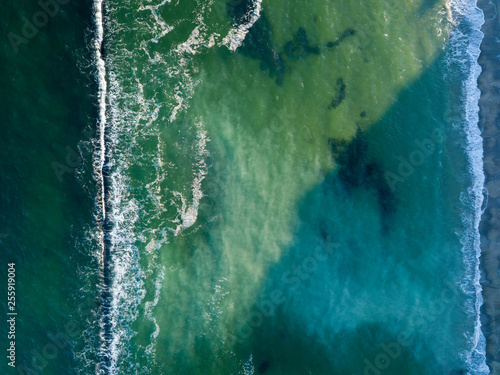 Ocean waves color of turquoise. Marine natural seascape background. Top view aerial from drone. Copy space.