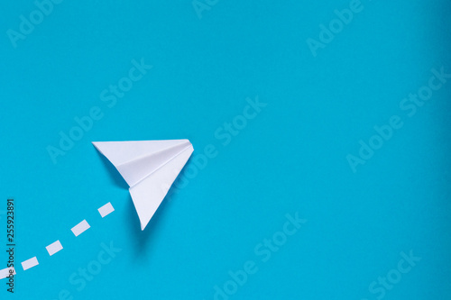 Closeup paper cut airplane in sky on blue background with copyspace. Concept of traveling, leisure, tourism, communication, message, email, news.