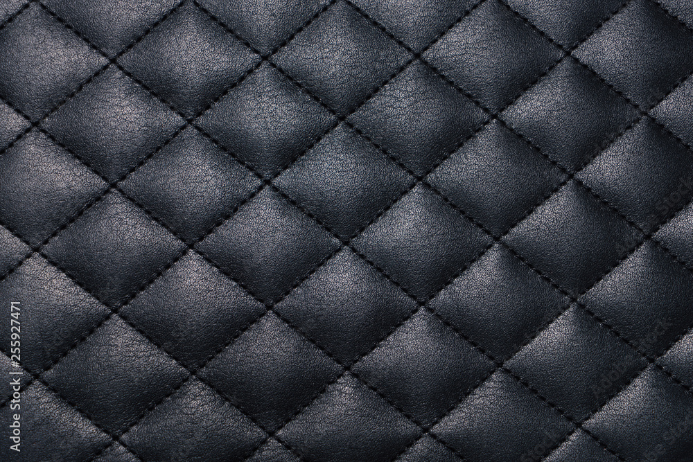 Fototapeta Black genuine leather texture background stitched with a thread across cross. Close up view from above.
