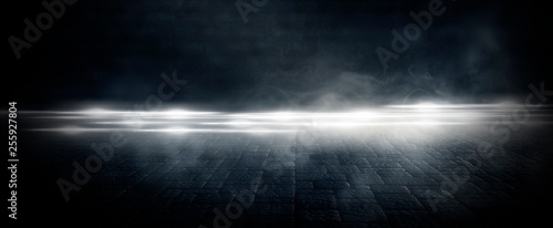 Wet asphalt, reflection of neon lights, a searchlight, smoke. Abstract light in a dark empty street with smoke, smog. Dark background scene of empty street, night view, night city.