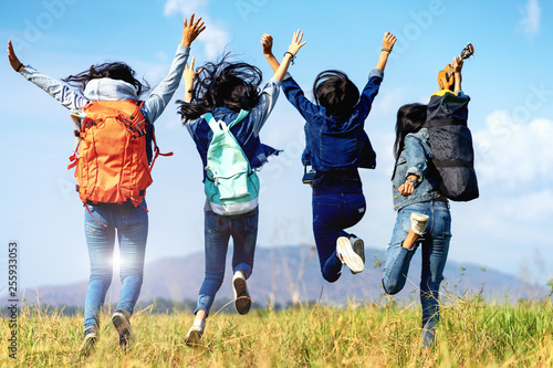 Trekking holiday concept.Four women are trekking in the mountains with backpack,tent,hiking equipment.