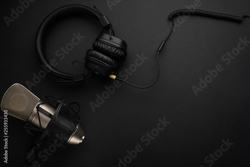 Studio microphone with headphones on a black background.Flat lay.Concept Radio, broadcasting, blog, studio, vocal, dikror