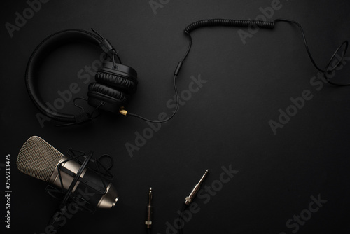 Studio microphone with headphones on a yellow background. Flat lay. Design. Radio and music. Stylish background