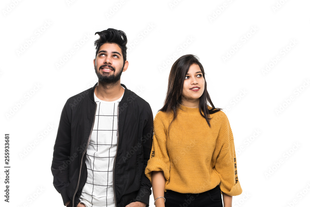 Young indian couple looking up against white background. Young indian couple looking up against white background.