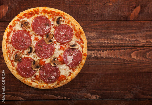 Pepperoni pizza on rustic, vintage style wood background. Top view