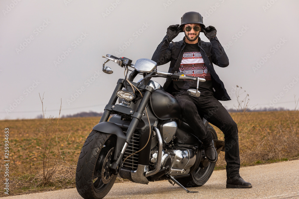 Handsome man on a black classic motorcycle Handsome man on a black classic motorcycle