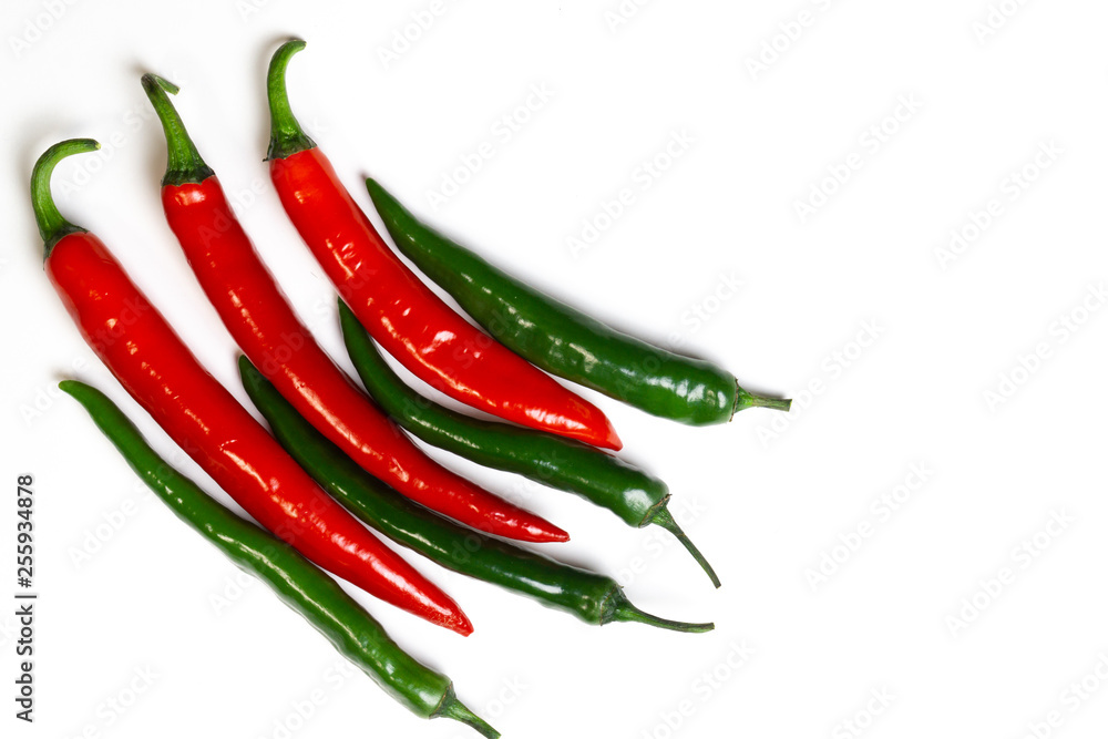 Green and red chili peppers on white background, top view. Hot spicy food symbol.