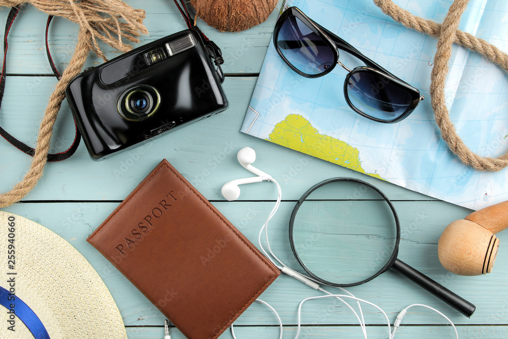 Travel concept Glasses, camera, passport, map and shells on a blue wooden table. relaxation. holidays. top view Travel concept Glasses, camera, passport, map and shells on a blue wooden table. relaxation. holidays. top view