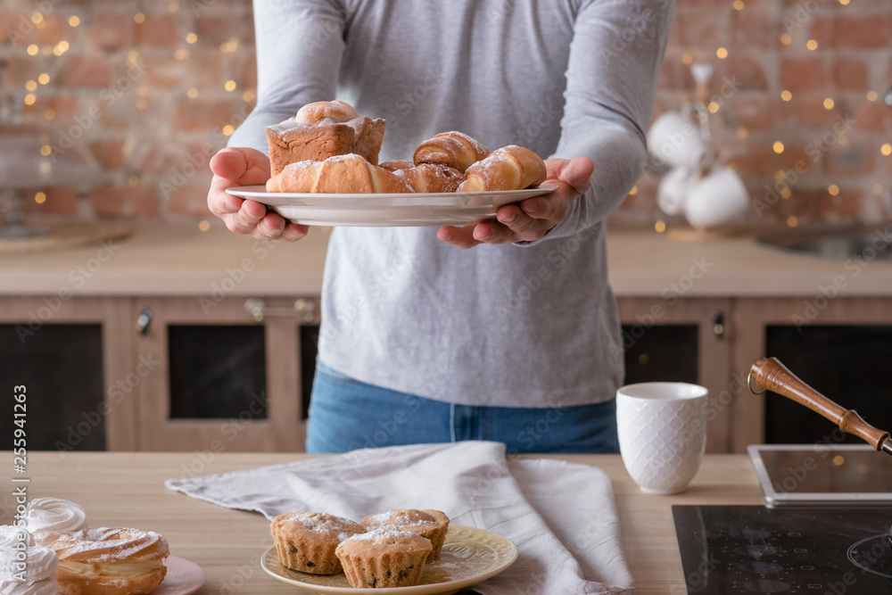 Cooking man. Hobby and lifestyle. Plates with yummy fresh cakes and pastries in hands. Midsection. Cooking man. Hobby and lifestyle. Plates with yummy fresh cakes and pastries in hands. Midsection.
