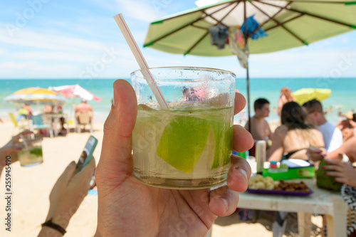 Wallpaper Mural Relax time at the beach in Marataizes, a little seaside village in the Espirito Santo state in Brazil. A hand holding a caipirinha a typical local drink Torontodigital.ca