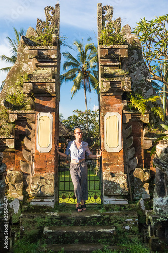 Young blonde caucasian woman traveling and exploring traditional hidu tamples around Ubud on Bali. Concept of luxury vacation, exploring and discovering the world. photo