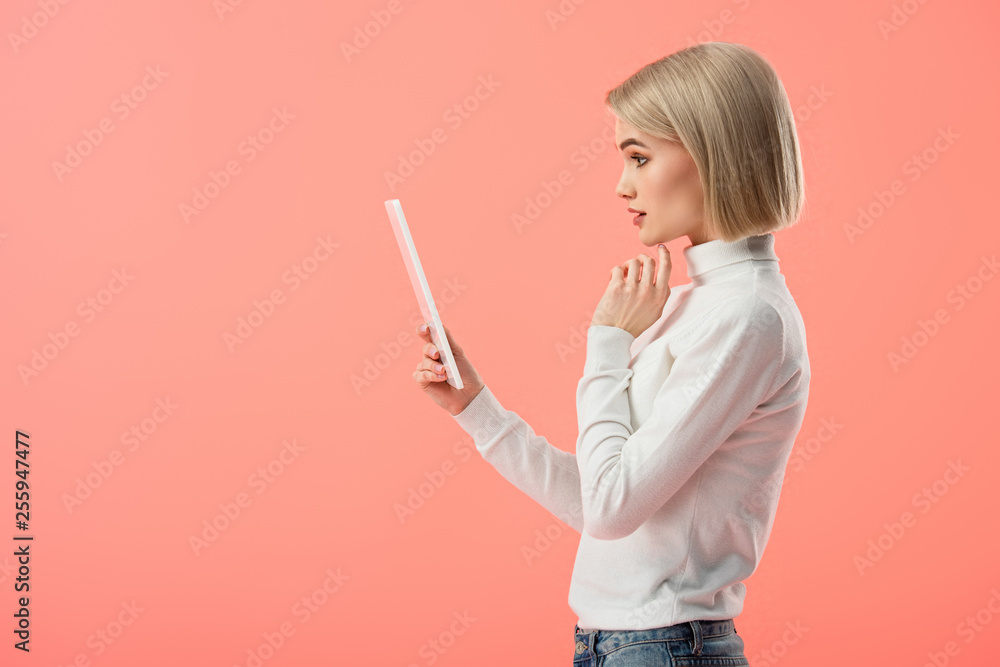 surprised blonde woman holding digital tablet isolated on pink surprised blonde woman holding digital tablet isolated on pink