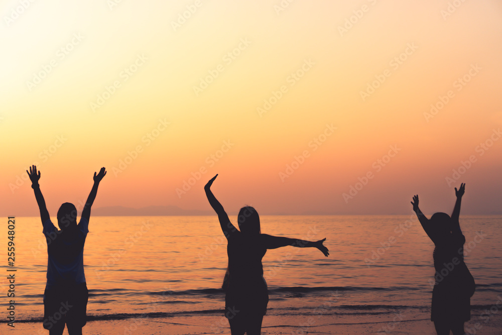A group of womans rise hands up to sky freedom concept with blue sky and beach background.
