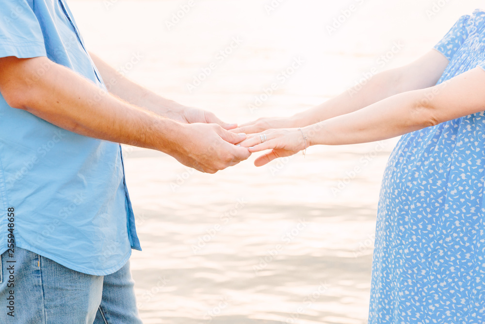 pregnant couple holding hands on beach pregnant couple holding hands on beach