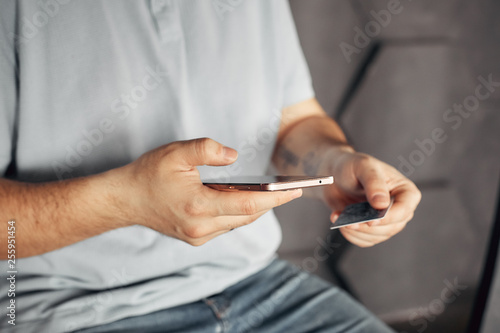 mobile payment and safe online transactions. digital finance and electronic operations. man holding credit card and phone.