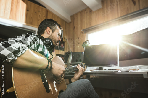 Vászonkép Man playing guitar in a recording studio