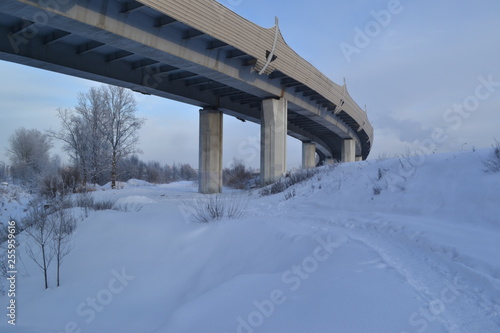 A concrete bridge winding over a snow-covered land