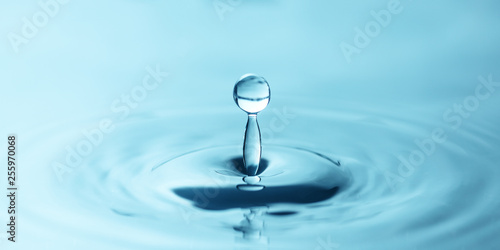 a drop of water close-up drips into the water, forming circles