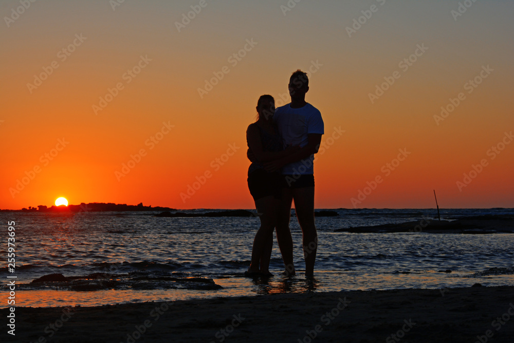 A couple on the background of a sunset