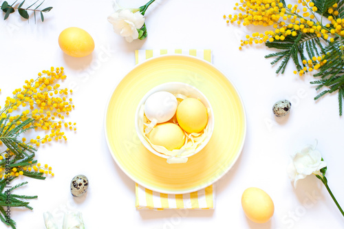 Easter table settings with painted eggs and spring flowers. Top view. Holiday flat lay
