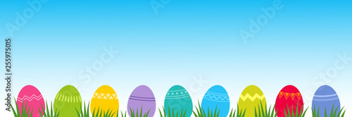 Bunte Ostereier Reihe auf Gras mit Himmel und Platz für Text
