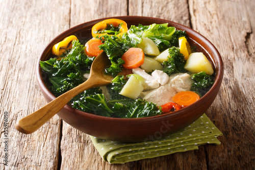 Easy vegetable soup recipe with kale and chicken close-up in a bowl on the table. horizontal