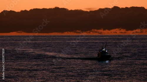 Long shot of fishing boat returning home.