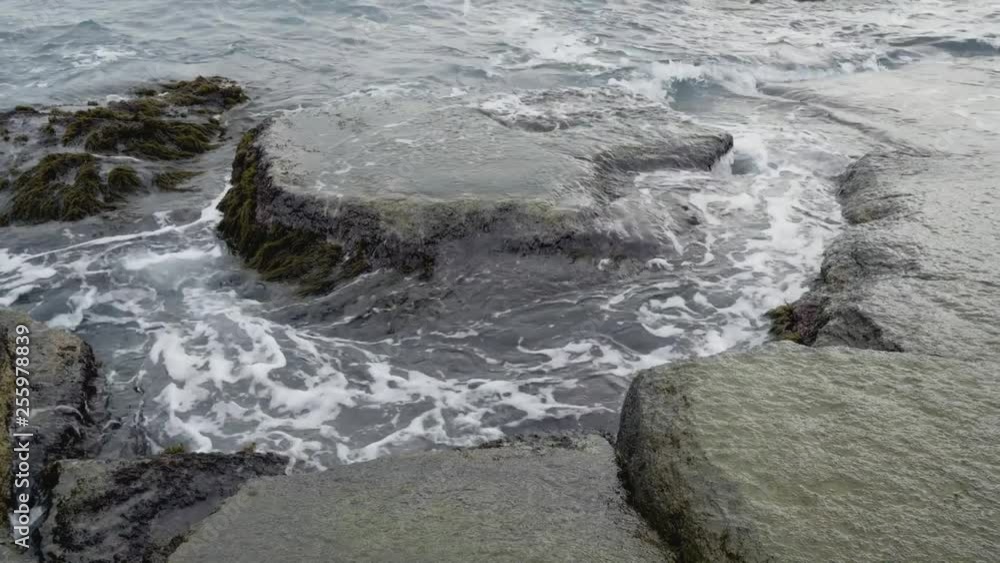 Sea wave washes mossy coastal boulders Sea wave washes mossy coastal boulders