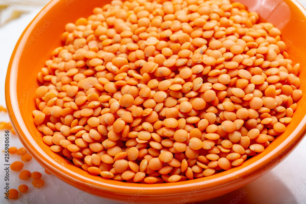 Dried orange lentils legume in orange bowl Dried orange lentils legume in orange bowl