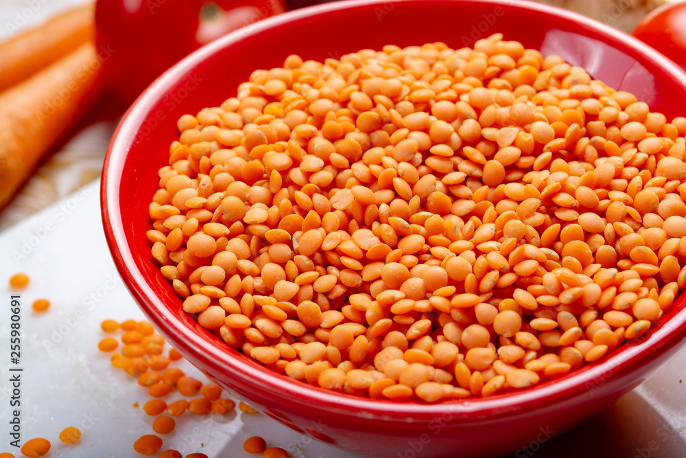 Dried orange lentils legume in red bowl Dried orange lentils legume in red bowl
