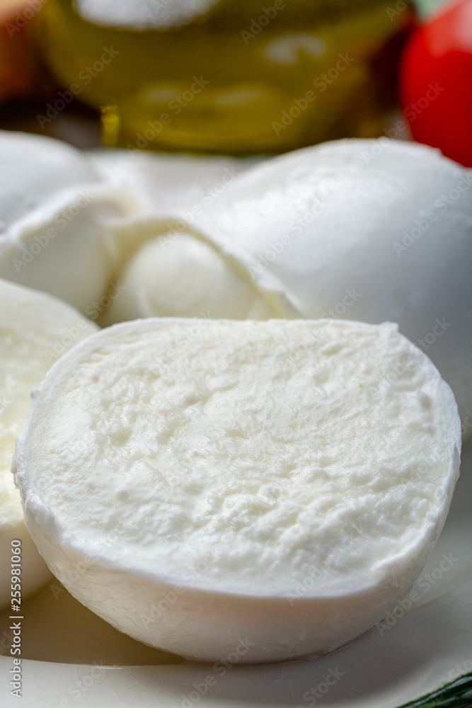 Balls and pieces of buffalo mozzarella, soft Italian scheese made from the milk of Italian Mediterranean buffalo Balls and pieces of buffalo mozzarella, soft Italian scheese made from the milk of Italian Mediterranean buffalo
