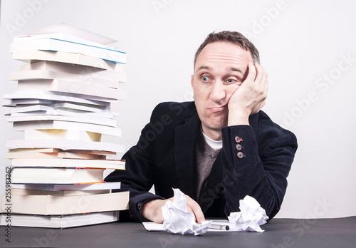 Fotografia Man with books on desk struggle with writing on white background