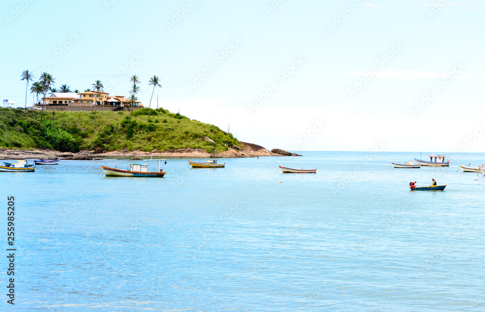 Naklejka premium A lovely bay with some little boats and a sand beach in Meaìpe a small fishing village near Guarapari in the Espirito Santo state in Brazil