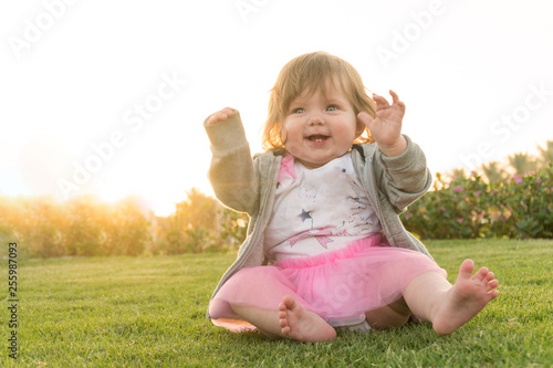 Smiling little cute girl having fun in the grass