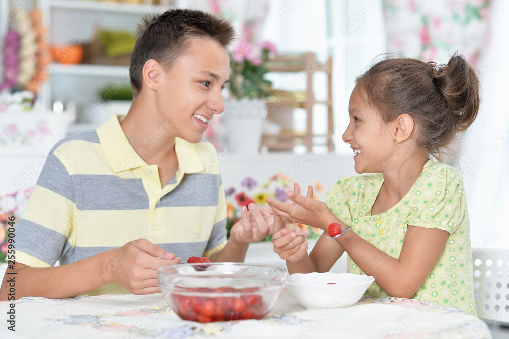 Happy brother and sister eating fresh strawberries Happy brother and sister eating fresh strawberries