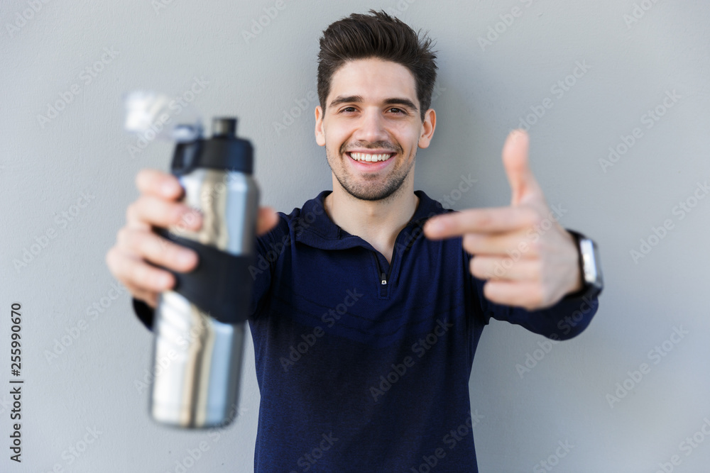 Confident smiling sportsman holding water bottle Confident smiling sportsman holding water bottle