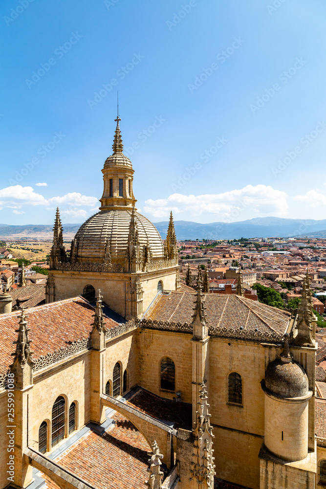 Segovia, Spain – View of the dome of the Cathedral and of Segovia old town from the top of the bell tower during Summer time. The peaks of Sierra de Guadarrama are visible behind