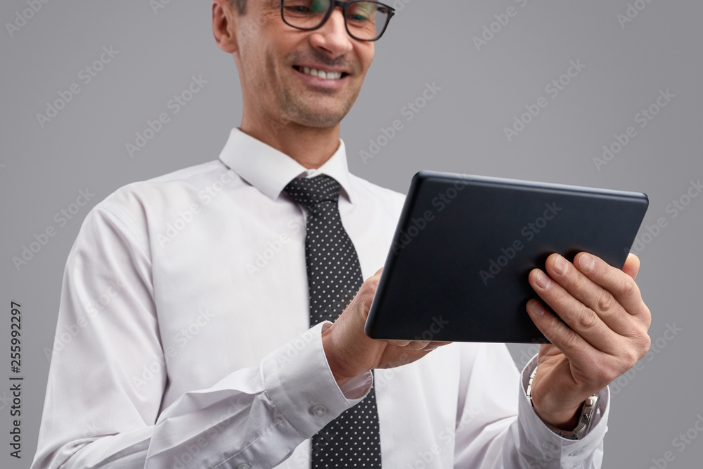 Crop businessman smiling and using tablet Crop businessman smiling and using tablet