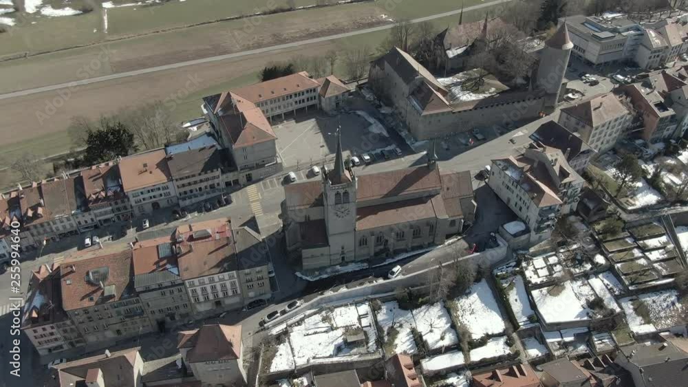 Wide aerial drone shot circling around a medieval church in the Swiss town Romont. Wide aerial drone shot circling around a medieval church in the Swiss town Romont.