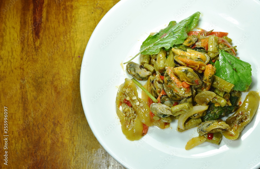 spicy stir fried mussel with basil leaf on plate spicy stir fried mussel with basil leaf on plate