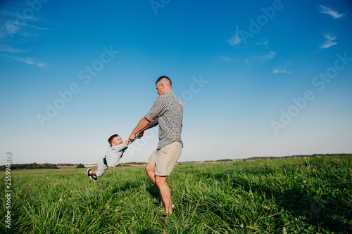 Cheerful dad playing with his child at the field